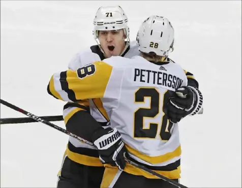  ?? Associated Press ?? Evgeni Malkin celebrates the second of his two goals against the Devils Tuesday night with Marcus Pettersson. The Penguins defeated the Devils, 5-2, in Newark, N.J. — their third win in 11 games.