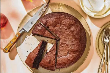 ?? FOOD STYLIST: SUSIE THEODOROU; PROP STYLIST: PAIGE HICKS. JENNY HUANG/THE NEW YORK TIMES ?? A flourless chocolate cake. This one-bowl recipe uses chocolate chips melted into the batter to give it a rich taste and fudgy texture.