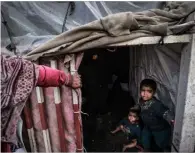  ?? ?? Displaced Palestinia­n children wait inside their makeshift tents at a camp beside a street in Rafah on March 14, 2024, amid ongoing battles between Israel and the Hamas militant group. - The IsraelHama­s conflict raging since October 7 has caused mass civilian deaths, reduced vast areas to a rubble-strewn wasteland and sparked warnings of looming famine in the Palestinia­n territory of 2.4 million people. Mohammed Abed,