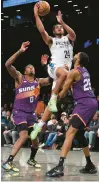  ?? AL BELLO/GETTY ?? Brooklyn guard Cam Thomas goes up for a shot over Phoenix forward Mikal Bridges during Tuesday night’s game at Barclays Center in Brooklyn, New York. The former Oscar Smith High star finished with 43 points.