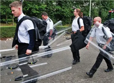  ??  ?? Disorder: Officers carrying riot shields head into HMP The Mount on Monday