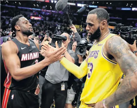  ?? AP PHOTO ?? Miami Heat guard Dwyane Wade, left, shakes hands with Los Angeles Lakers forward LeBron James at the end of Monday’s NBA game in Los Angeles.