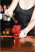  ?? YORK TIMES LANNA APISUKH/THE NEW ?? A bartender tops off a Dirty Shirley with maraschino cherries, just like the kid-friendly drink, at Fanelli’s Cafe in New York. Vodka-spiked Shirley Temples, nostalgic, colorful and unapologet­ically sweet, have found a way to upstage the vodka soda.