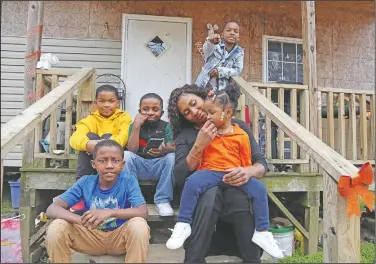  ??  ?? Annie Turner sits with five of her six children, (from top left) Kendell Turner Jr., 10; Keydon Turner, 6; Kendrell Turner, 9; Kemiya Turner, 2, and Kejuan Turner, 8, in front of their home in Fayette. She said receiving food from the school helps supplement what she is able to provide. It’s tough being the family’s breadwinne­r during a pandemic.
(AP/Leah Willingham)