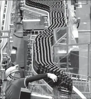  ?? AP/KOJI SASAHARA ?? In May, an Asahi Breweries employee works on the production line at a factory in Moriya near Tokyo.