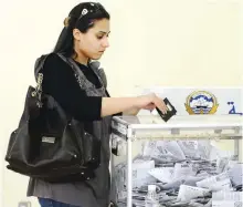  ??  ?? A Kuwaiti woman casts her vote in the 2009 parliament­ary elections.