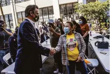  ?? Stephen Lam / The Chronicle ?? Gov. Gavin Newsom greets a supporter during a campaign visit at Mission Language and Vocational School in San Francisco.