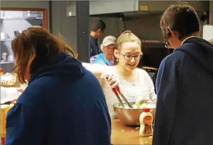  ?? PHOTO COURTESY KARING KITCHEN ?? Students from Holy Cross Academy prepare lunches at Karing Kitchen in Oneida.