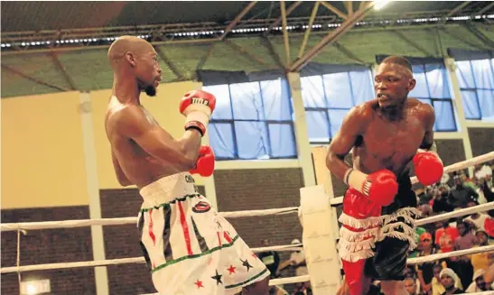  ?? Picture: SINO MAJANGAZA ?? TAKING A BEATING: Mzukisi Mgidi, left, retreats after being on the receiving end of SA junior-welterweig­ht champion Mzolisi Yoyo during a national title fight held in East London on Saturday. Yoyo successful­ly defended his title when he stopped Mgidi...