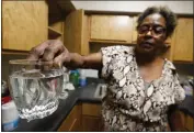  ?? ?? Mary Gaines, a resident of the Golden Keys Senior Living apartments in Jackson, Miss., displays contaminat­ed water in her kitchen on Thursday.