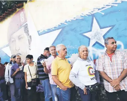  ??  ?? ► Un grupo de electores espera su turno para votar, ayer en Caracas.