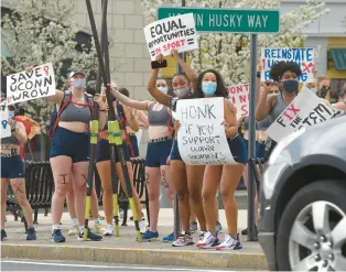  ?? COURANT FILE PHOTO ?? Members of the Uconn women’s rowing team rally in downtown Storrs in April 2021 when their sport was being cut by the university. The team filed a Title IX complaint and won.