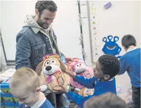  ??  ?? Mata presents gifts to pupils at Beever Primary School.