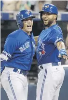  ?? FRED THORNHILL/ THE CANADIAN PRESS ?? Toronto’s Ryan Goins, left, celebrates his grand slam against the New York Yankees with Richard Urena Friday at Rogers Centre.