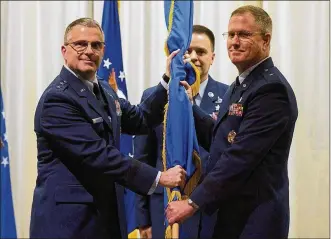  ?? R.J. ORIEZ PHOTOS / U.S. AIR FORCE ?? Maj. Gen. William T. Cooley, Air Force Research Laboratory commander, presents Brig. Gen. James H. Dienst with the 711th Human Performanc­e Wing’s guidon as Dienst assumes command of the wing June 21 during a ceremony in the National Museum of the U.S. Air Force. Senior Master Sgt. Christophe­r Sutor stands by to post the guidon.