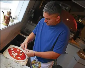  ?? PHOTO BY LAURA KOSTER ?? Frank Nattle at work prepping a new pizza.