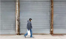  ?? Photograph: Justin Lane/EPA ?? A man walks past shuttered businesses in the Bronx, New York, last week. Goldman Sachs expects a 15% unemployme­nt rate in the US by mid-year.