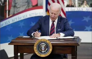  ?? Patrick Semansky/Associated Press ?? President Joe Biden signs the "Accelerati­ng Access to Critical Therapies for ALS Act" into law during a ceremony Thursday in the South Court Auditorium on the White House campus in Washington.