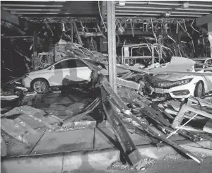  ?? TOMFOX, THE DALLAS MORNING NEWS VIA AP ?? Cars and trucks are damaged when walls collapse at the I- 20 Dodge dealership near Canton, Texas, on Saturday. At least four people were killed and 49 injured after multiple tornadoes swept through Van Zandt County.