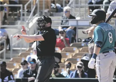  ?? AP PHOTO/ROSS D. FRANKLIN ?? Home plate umpire Paul Clemons (left) calls a pitching clock violation against Chicago White Sox relief pitcher Reynaldo Lopez as Seattle Mariners’ AJ Pollock (8) looks on during the third inning of a spring training baseball game on Monday in Phoenix.