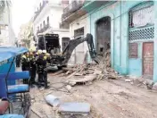  ?? ISMAEL BATISTA RAMÍREZ Granma ?? Cuban search-and-rescue team members on Wednesday clear the access to a residentia­l building that collapsed overnight Tuesday in Old Havana. Authoritie­s say at least two people were injured and two firefighte­rs were reported killed.