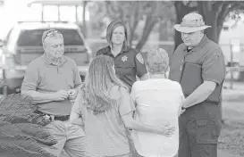  ?? Melissa Phillip / Houston Chronicle ?? Investigat­ors talk to a woman, right, who identified herself as the sister of Sandra Bienek, who was found shot to death Wednesday at her Beach City home. Bienek’s husband, Chester, also was slain. Their grandson has been charged.