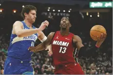  ?? AARON GASH/AP ?? MIAMI HEAT’S BAM ADEBAYO (13) drives to the basket against Milwaukee Bucks’ Brook Lopez during the first half of a game on Tuesday in Milwaukee.