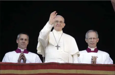  ?? ALESSANDRA TARANTINO — THE ASSOCIATED PRESS ?? Pope Francis waves to faithful during the Urbi et Orbi (Latin for ‘ to the city and to the world’ ) Christmas Day blessing from the main balcony of St. Peter’s Basilica at the Vatican.