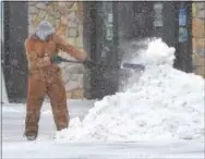  ?? PETE BANNAN – DIGITAL FIRST MEDIA ?? A man shovels a pile of snow in front of the Sherwin WIlliams paint store on West Chester Pike in West Goshen Thursday morning.