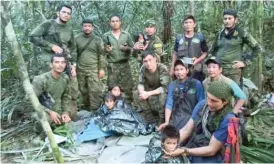  ?? COLOMBIA’S ARMED FORCE PRESS OFFICE VIA AP ?? Colombian soldiers and Indigenous men pose Friday for a photo with four brothers who were missing for 40 days after a deadly plane crash.