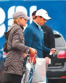  ?? Rex features ?? Rory McIlroy and his wife Erica leave the course during the Dubai Duty Free Irish Open at Portstewar­t Golf Club, Londonderr­y earlier this month.