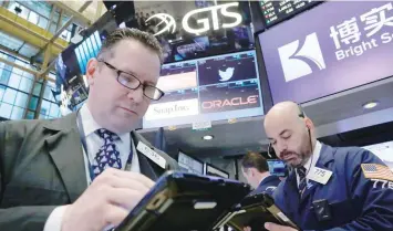  ?? — Reuters ?? Traders work on the floor of the New York Stock Exchange in New York.