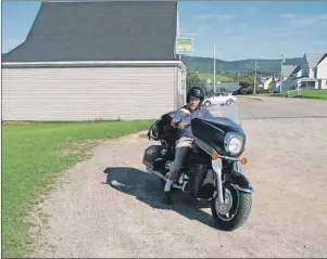  ?? SUBMITTED PHOTO ?? George Thomas tries out my Yamaha touring bike on Main street in Margaree Harbour, with Lawrence’s General Store on the left.