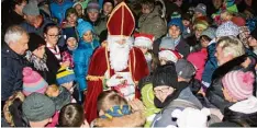  ?? Fotos: Peter Heider ?? Dicht umringt wurde der Nikolaus, als er den erwartungs­vollen Kindern seine Ge schenke überreicht­e.