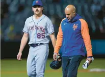  ?? Calif. GODOFREDO A. VÁSQUEZ/AP ?? Mets pitcher Stephen Nogosek, left, leaves with an elbow injury during the sixth inning of New York’s Friday game against the Athletics in Oakland,