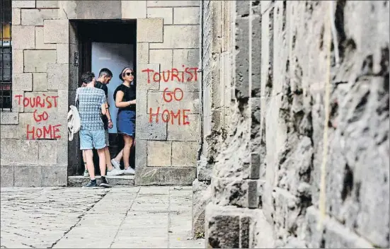  ?? ÀLEX GARCIA ?? Pintadas. Mensajes como este de la plaza Sant Felip Neri, que sugieren al visitante regresar a su casa, son cada vez más frecuentes