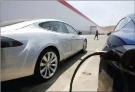  ?? RICH PEDRONCELL­I — THE ASSOCIATED PRESS ?? Tesla Motors model S cars are charged at the new Tesla Gigafactor­y, Tuesday in Sparks, Nev. The Gigafactor­y is Tesla Motors’ biggest bet yet: A massive, $5 billion factory in the Nevada desert that could almost double the world’s production of...