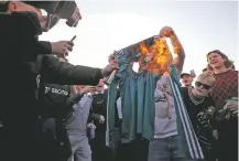  ?? ZAC GOODWIN/ASSOCIATED PRESS ?? Fans burn a Liverpool replica shirt Monday outside Elland Road in Leeds, England, as a protest against Liverpool’s decision to be included amongst the clubs attempting to form a new European Super League. Reaction to the proposals from 12 clubs to rip up European soccer by forming a breakaway Super League has ranged from anger and condemnati­on to humor and sarcasm.