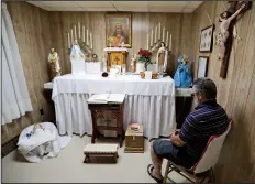  ?? AP/TONY DEJAK ?? Ron Sattler sits in the chair where Rhoda Wise said she was visited by Jesus Christ in front of the altar in Canton, Ohio. Eighty years after Rhoda Wise first claimed she was a receiver of Christian miracles, people are still visiting her Ohio home to see for themselves.