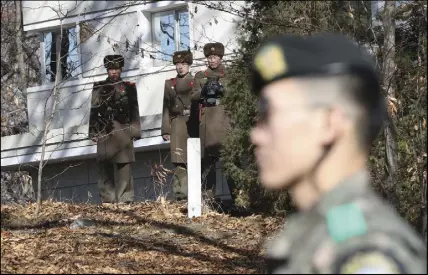  ?? Ap photo ?? North Korean soldiers look at a South Korea solider across the Demilitari­zed Zone.