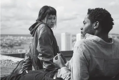  ?? IFC FILMS ?? UP ON THE ROOF: Emilie Wong (Lucie Zhang) and Camille Germain (Makita Samba) hang out on the rooftop.