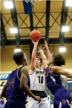  ?? Staff photo by Evan Lewis ?? right Pleasant Grove’s Connor Ouellette shoots from the top of the key as Center’s Kaleb Parks and Kyle Parker defend Tuesday in Longview, Texas.