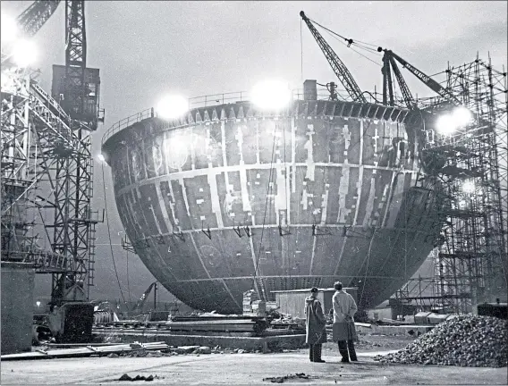  ??  ?? Men look at the bottom half of the Dounreay reactor, a steel ball 135-ft wide, during constructi­on in July 1956. It is now being decommissi­oned