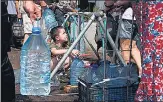  ?? REUTERS ?? Olexander Bulba, 7, collects water for his father Grigorii at a Red Cross distributi­on point, in Mykolaiv, Ukraine.