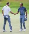  ?? PHOTO: GETTY IMAGES ?? Dustin Johnson (left) shakes hands with Tiger Woods on the 18th green during the first round of the US Open at Shinnecock in Southampto­n, New York, yesterday.