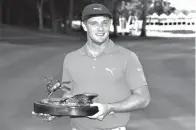  ?? Associated Press ?? ■ In this July 16, 2017, file photo, Bryson DeChambeau celebrates with the trophy after winning the John Deere Classic golf tournament at TPC Deere Run in Silvis, Ill. DeChambeau will defend a title for the first time in his career this week at the...