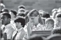  ?? Staff Photo by Mark Gilliland ?? Kristin Vines, a Latin teacher at Baylor School, along with the lower school student body, attends a 9/11 memorial service Monday in the Alumni Chapel.