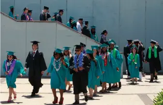  ?? Paul Chinn / The Chronicle ?? Graduates march in a ceremony at Phillip and Sala Burton Academic High School in San Francisco in 2014. Some 4,000 students graduated from the city’s public high schools this year.