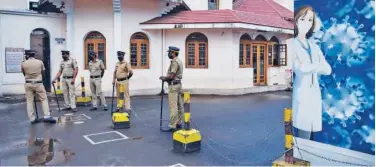  ?? Associated Press ?? ↑
Policemen stand guard next to markings made to ensure physical distancing outside the Kochi Special Economic Zone on Thursday.