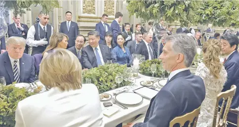  ?? — AFP photo ?? In this handout picture released by Argentina’s Presidency, Argentina’s President Mauricio Macri (right, back to camera) attends a banquet with (from left) Trump, US First Lady Melania Trump, Xi, China’s First Lady Peng Liyuan, Russian President Vladmir Putin and other G20 leaders and their spouses after a gala at the Colon Theater in Buenos Aires, in the sidelines of the G20 Leader’s Summit.